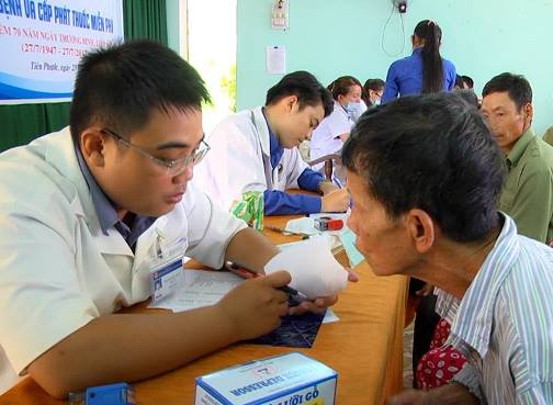 Các nhân viên y tế khám bệnh, tư vấn sức khỏe, phát thuốc miễn phí cho các thương, bệnh binh, gia đình chính sách tại xã Tiên Mỹ